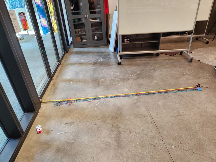 Photo of stretching out the parachute cords and cutting them to length.