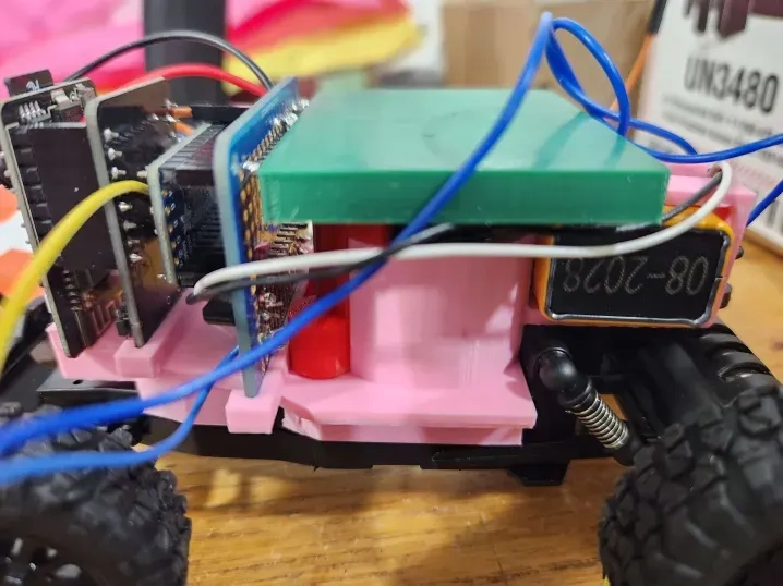 Close-up photo of 3D-printed rover mounting plate with components attached.