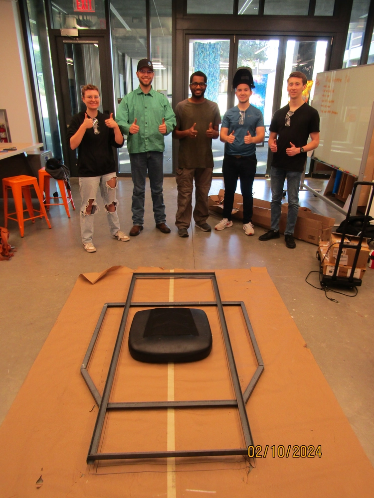 Group photo of MACH team after welding base layer of frame.