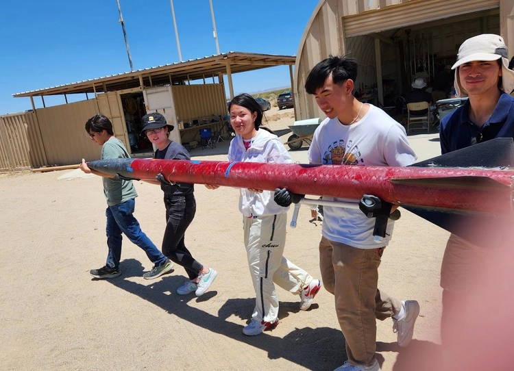 Photo of teammates carrying Gladius II to the launch officials for inspection before launch.
