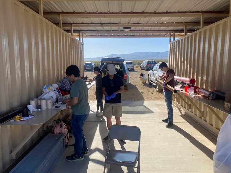 Photo of team preparing the motor casing by lubricating the motor tube and sliding in solid fuel.