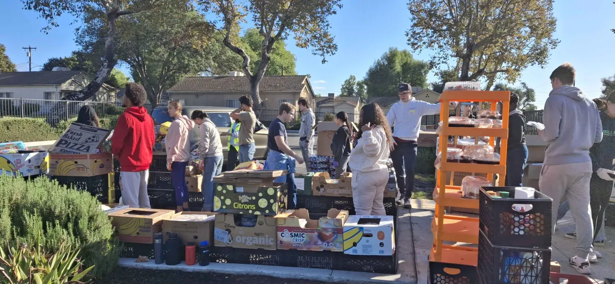 Photo of 5CIV members loading boxes of donated food into underprivileged families' cars.