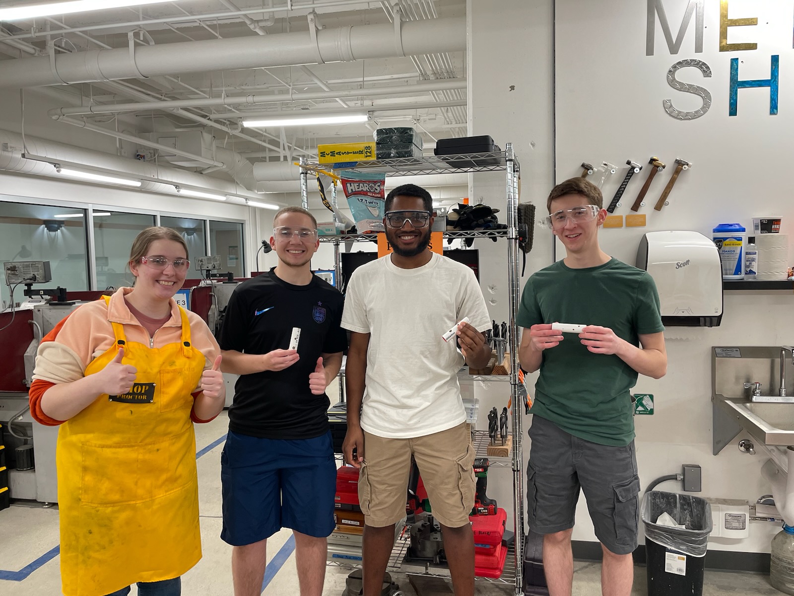 Group photo of Jacob and friends in the machine shop after finishing their E4 ocarinas.